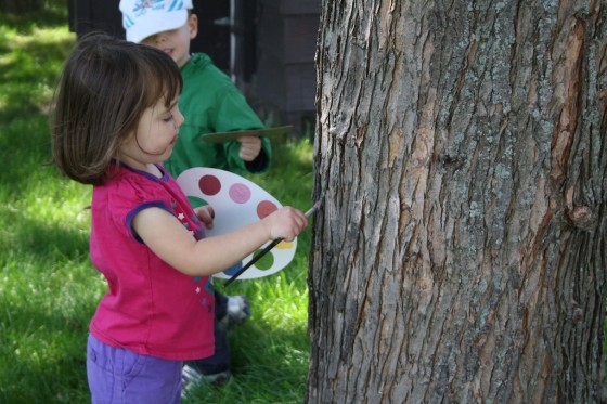 toddlers using pretend paint palette to paint the trees