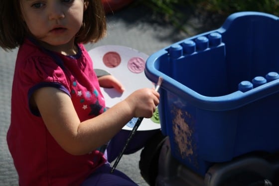 toddler pretending to paint toys with paintbrush and pretend play paint palette