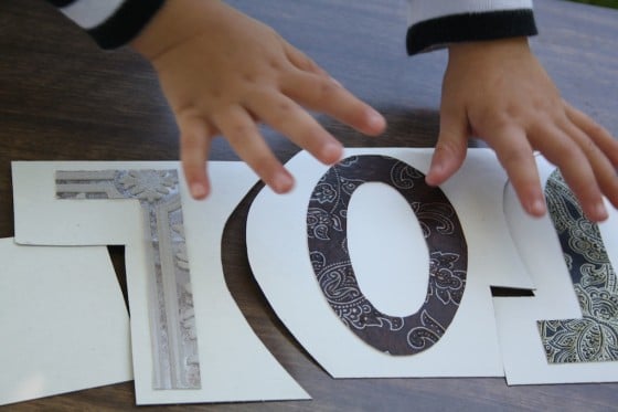 preschooler putting together cardboard name puzzle 