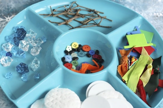 snowman building activity tray filled with supplies