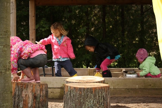 children playing in sandbox and on play logs