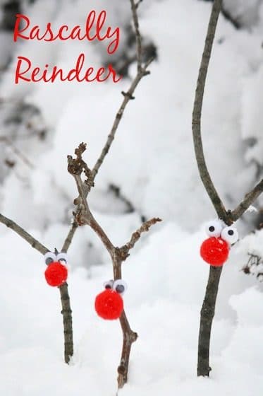 3 stick reindeer with red pom pom noses stuck into the snow