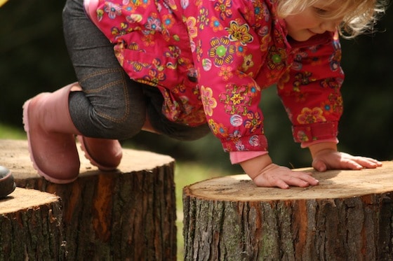 toddler climbing from one playlog to another