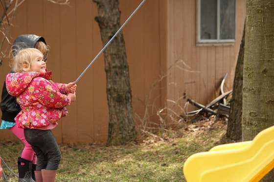 two kids pulling rope to hoist the bucket 