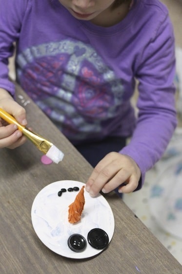 gluing buttons and beans on a CD snowman ornaments