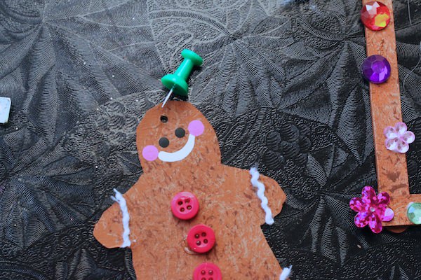 poking hole in gingerbread man with thumbtack