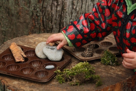 toddler making mud pies on play log