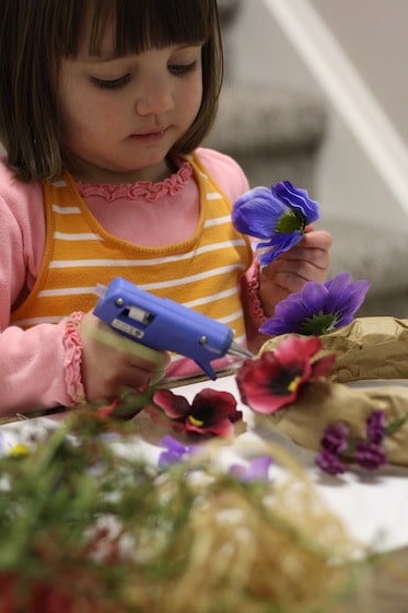 low heat glue gun used by child making paper bag tiara