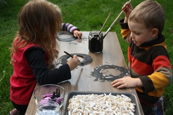 preschoolers painting black paper plate wreaths for Halloween