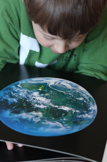 young boy looking at satellite picture of planet Earth