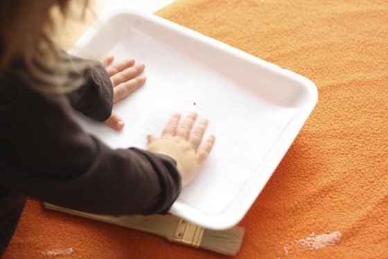 gluing felt sheet to styrofoam tray for snowman face art