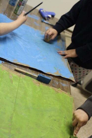 toddlers painting paper bags for mermaid crown 