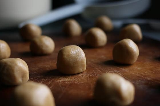 Rolled balls of peanut butter cookie dough on baking stone