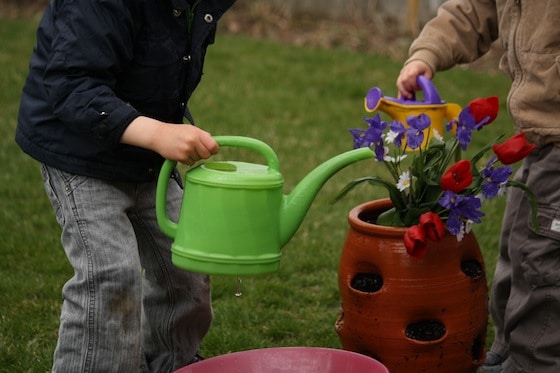 preschoolers pretending to water flowers