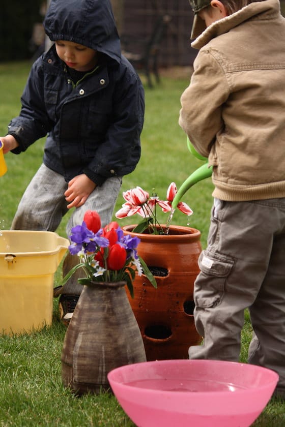 boys water fake flowers in flower pots