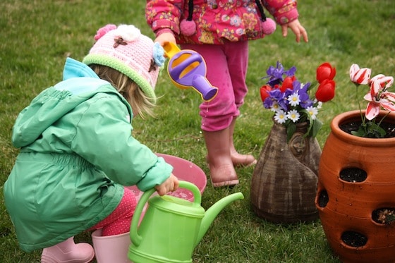 toddlers planting artificial flowers in flower pot