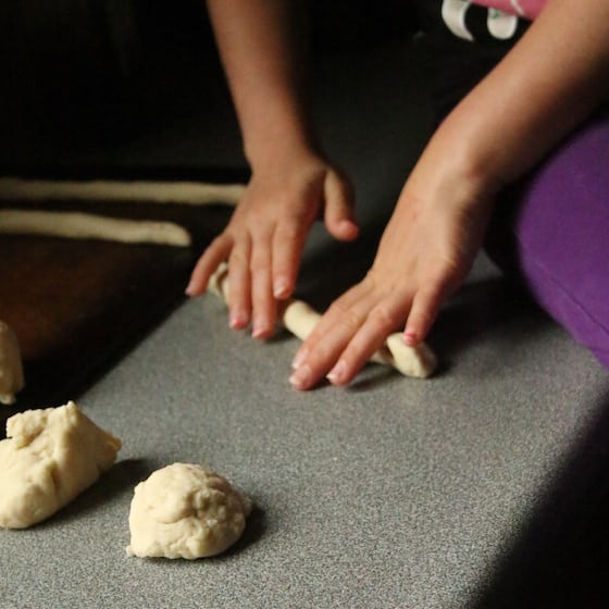 Rolling dough into pretzels