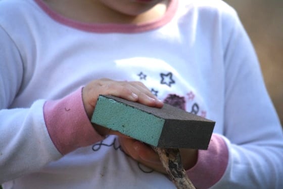 preschooler using sanding blocks and sandpaper