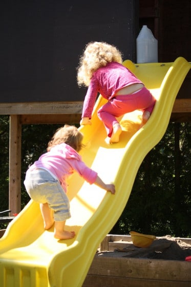 balancing activity - toddler and preschooler climbing up the slide