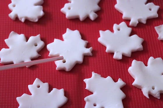 using straw to poke hole in clay dough fall leaf cut-outs