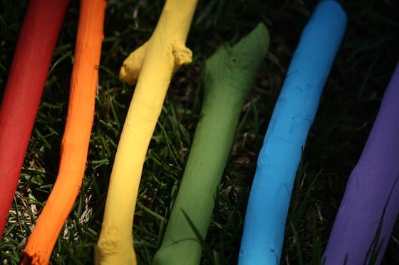 rainbow painted sticks laid out in grass