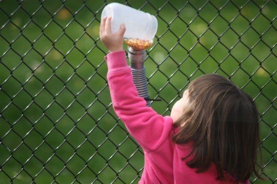 toddler playing with corn run with funnels and hoses