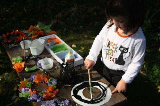 child painting paper plate wreath for halloween