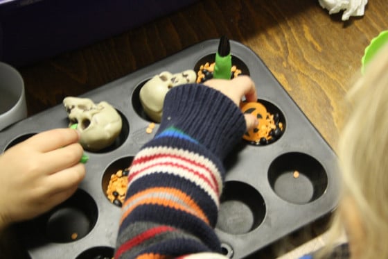 transferring and sorting sensory bin items in a mini muffin tin