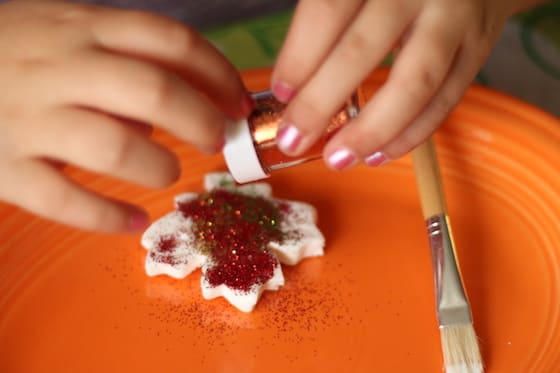 sprinkling Martha Stewart copper glitter on a claydough leaf