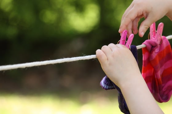 preschooler pinning to clothesline for fine motor development