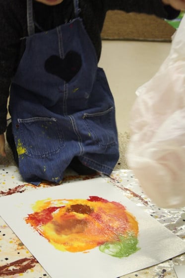 child lifting bag off smoosh painted pumpkin