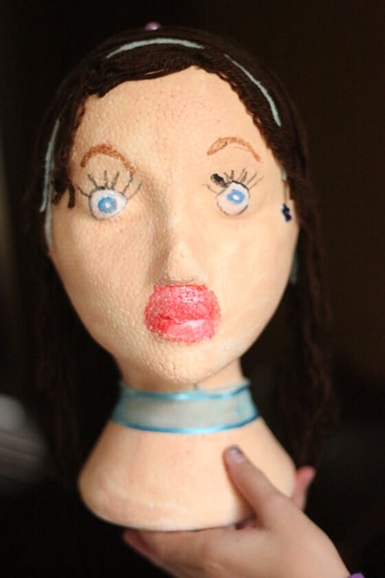 Styrofoam mannequin head decorated by child