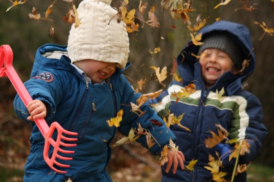 preschool boys throwing fall leaves in the air