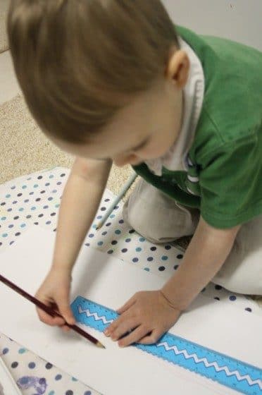 Toddler using pencil and ruler