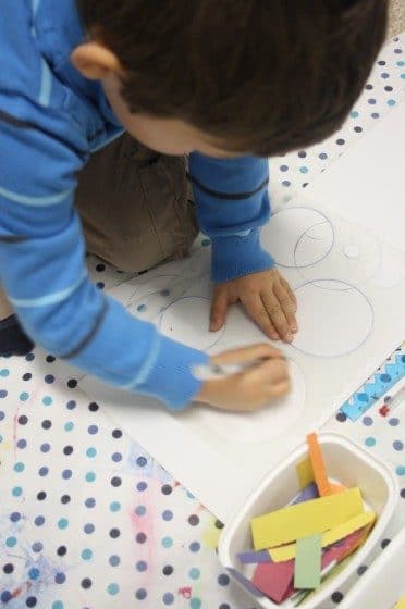 Preschooler drawing circles with stencil 