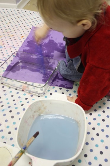 Baby painting on construction paper with water