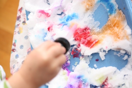 toddler uses liquid watercolours to colour the snow