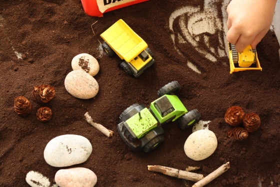 construction sensory bin with coffee grounds