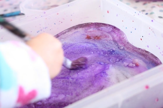 toddler melting heart shaped ice block with salt and purple water