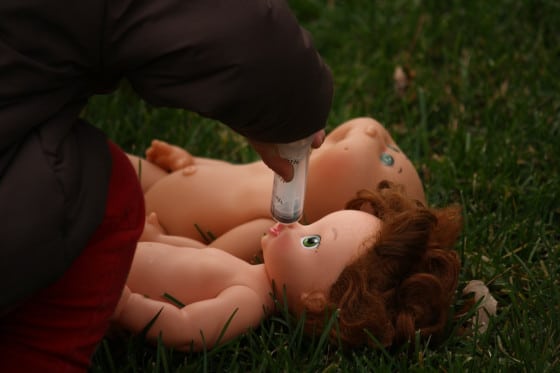 preschooler giving doll pretend medicine