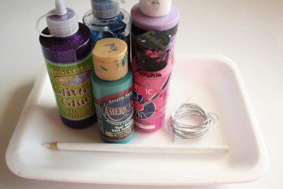 paint, styrofoam tray, glitter glue, white pencil crayon, string