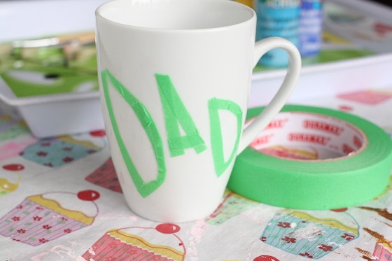 Dad spelled in painters tape on a white mug