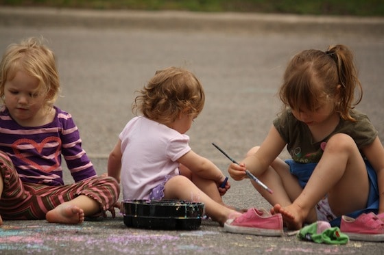 preschoolers painting driveway with homemade chalk paint