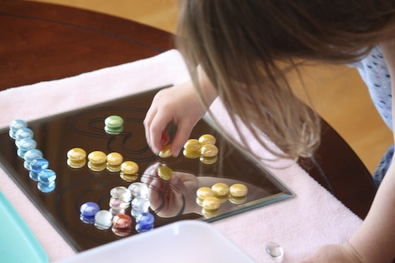 placing glass beads on a drawing on a mirror