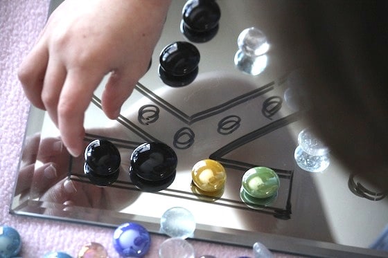 placing glass beads on a drawing on a mirror