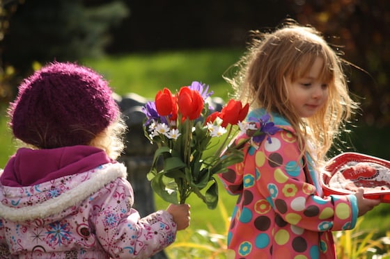 preschoolers holding pretend parade holding flowers