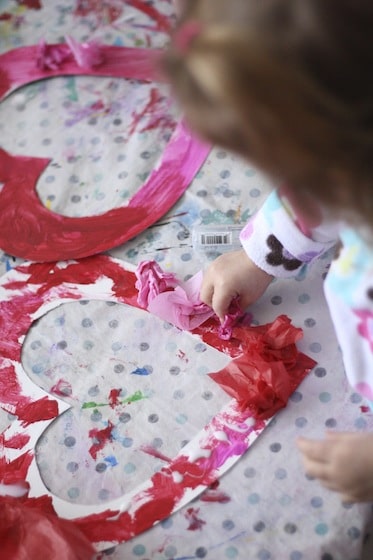 gluing tissue paper to a heart shaped wreath