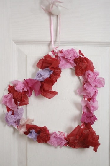 tissue paper Valentine wreath hanging from a door