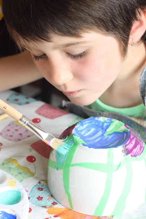 child painting bowl with tape resist technique