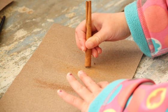 child rubbing cinnamon stick on sandpaper